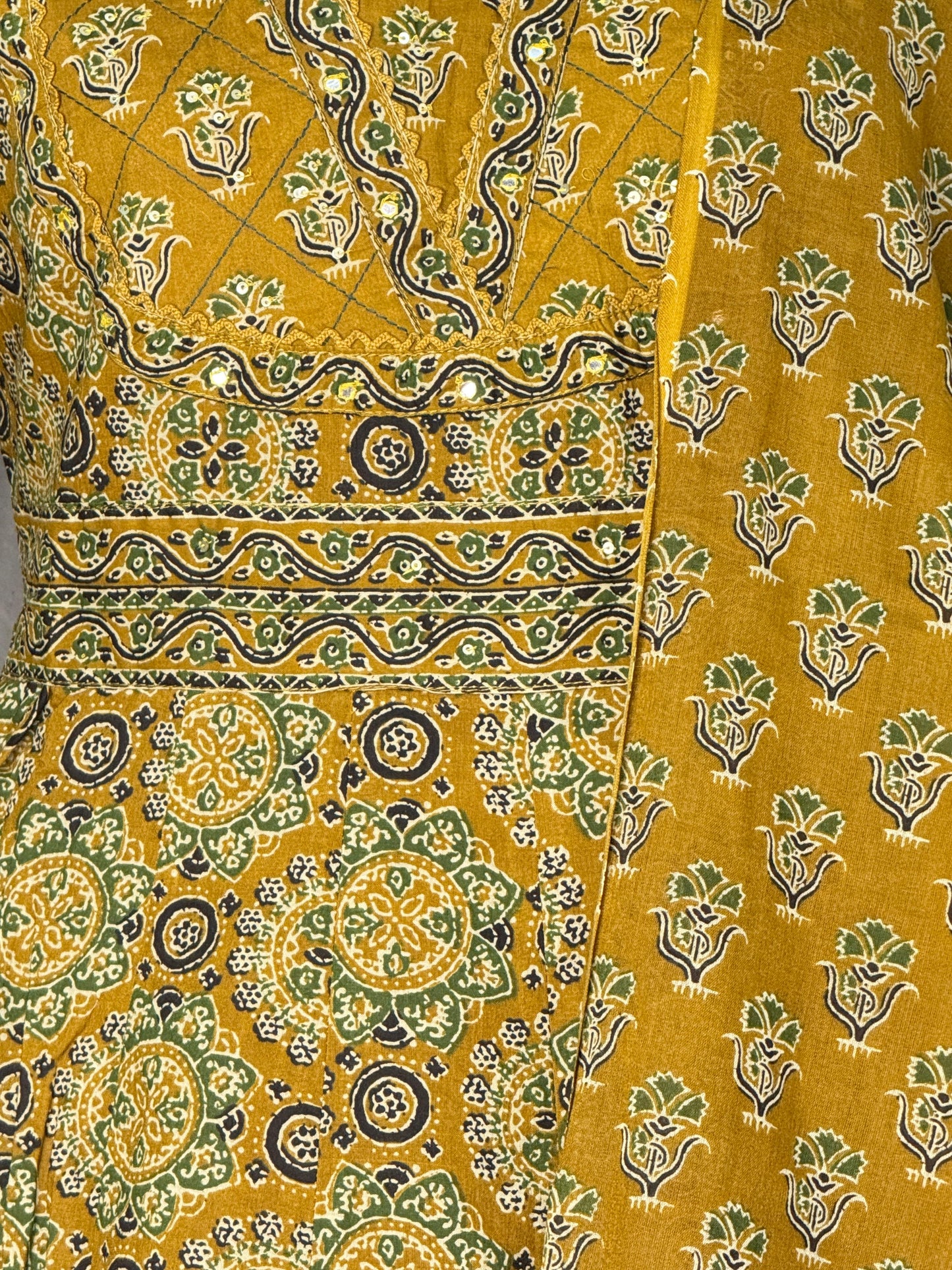 Close-up of yellow fabric with green and black floral patterns