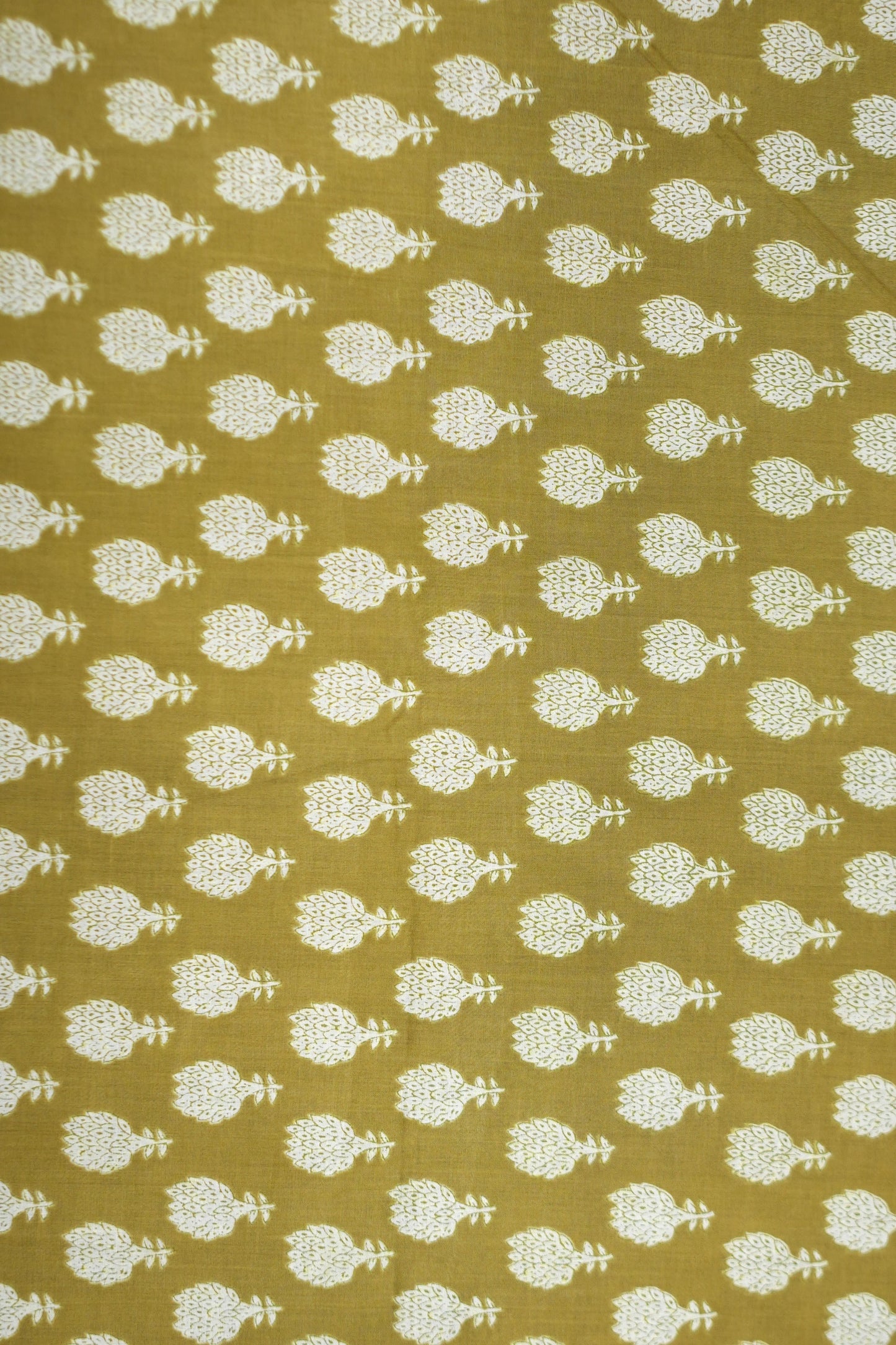 Patterned fabric with white floral design on a mustard yellow background
