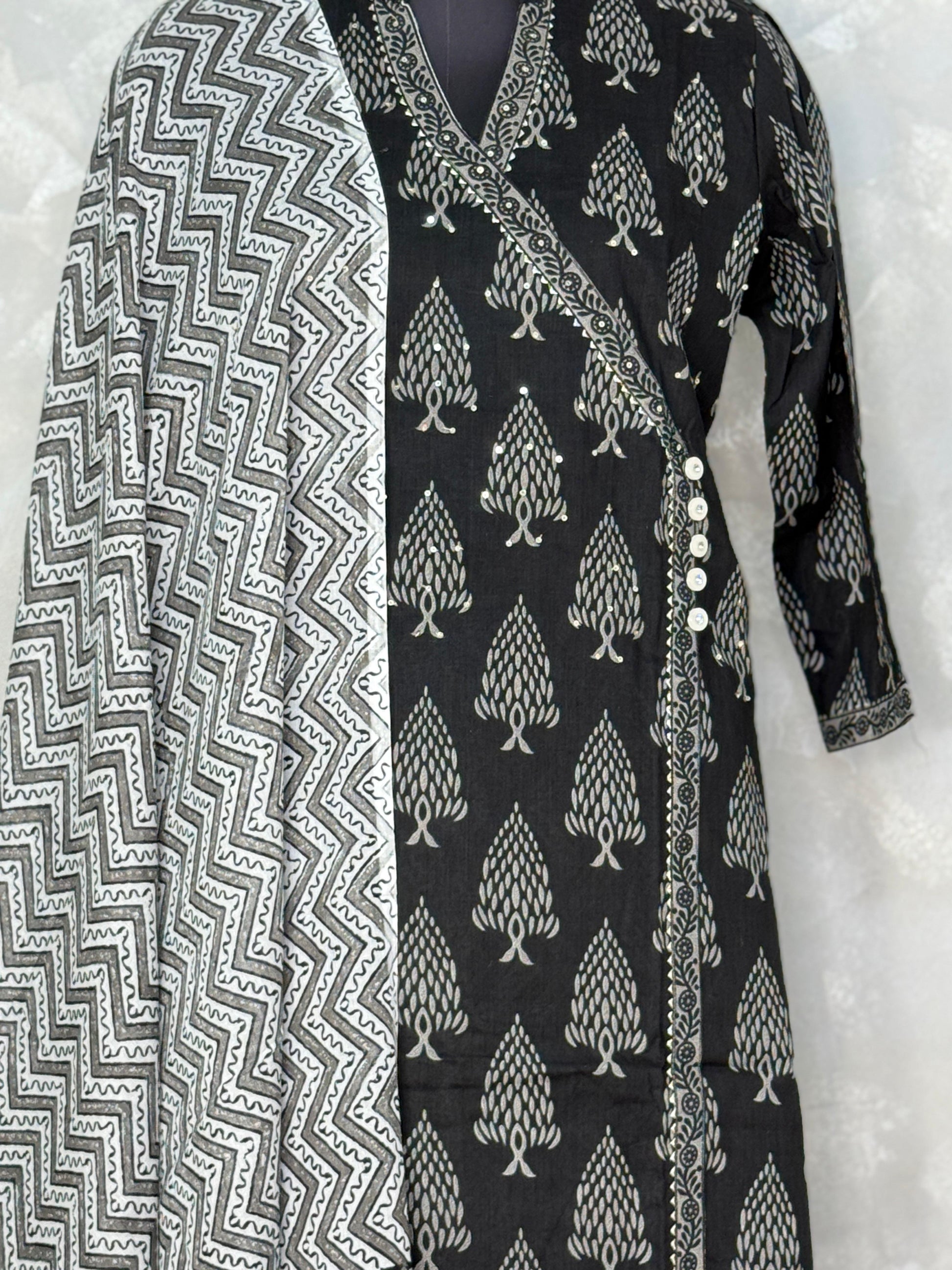 Black and white patterned dress with a matching scarf on a light gray background