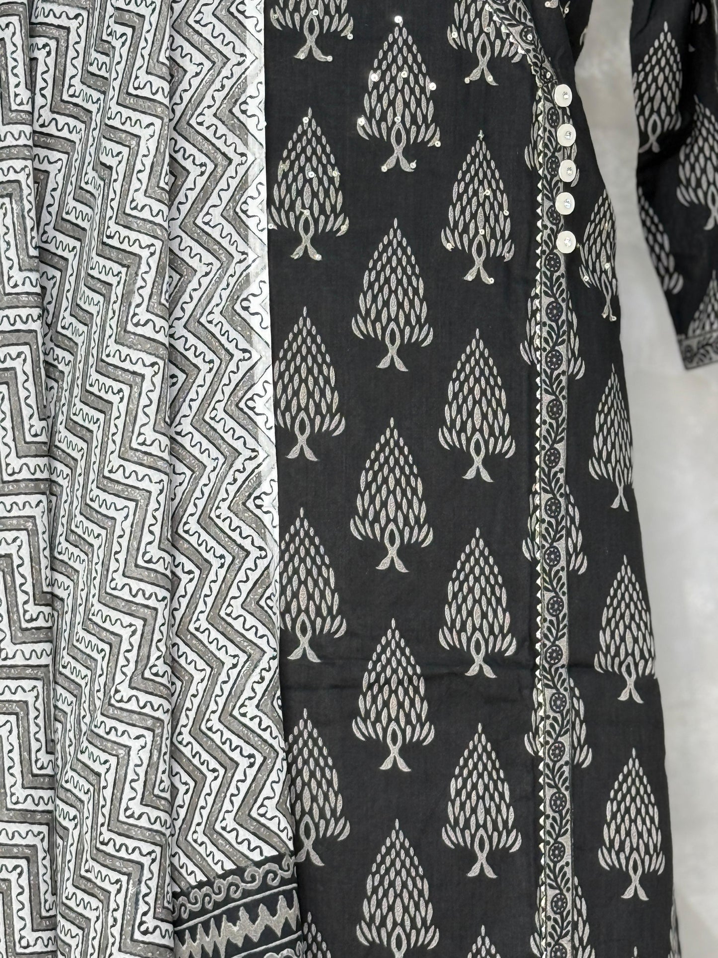 Black fabric with white tree pattern next to gray fabric with zigzag pattern