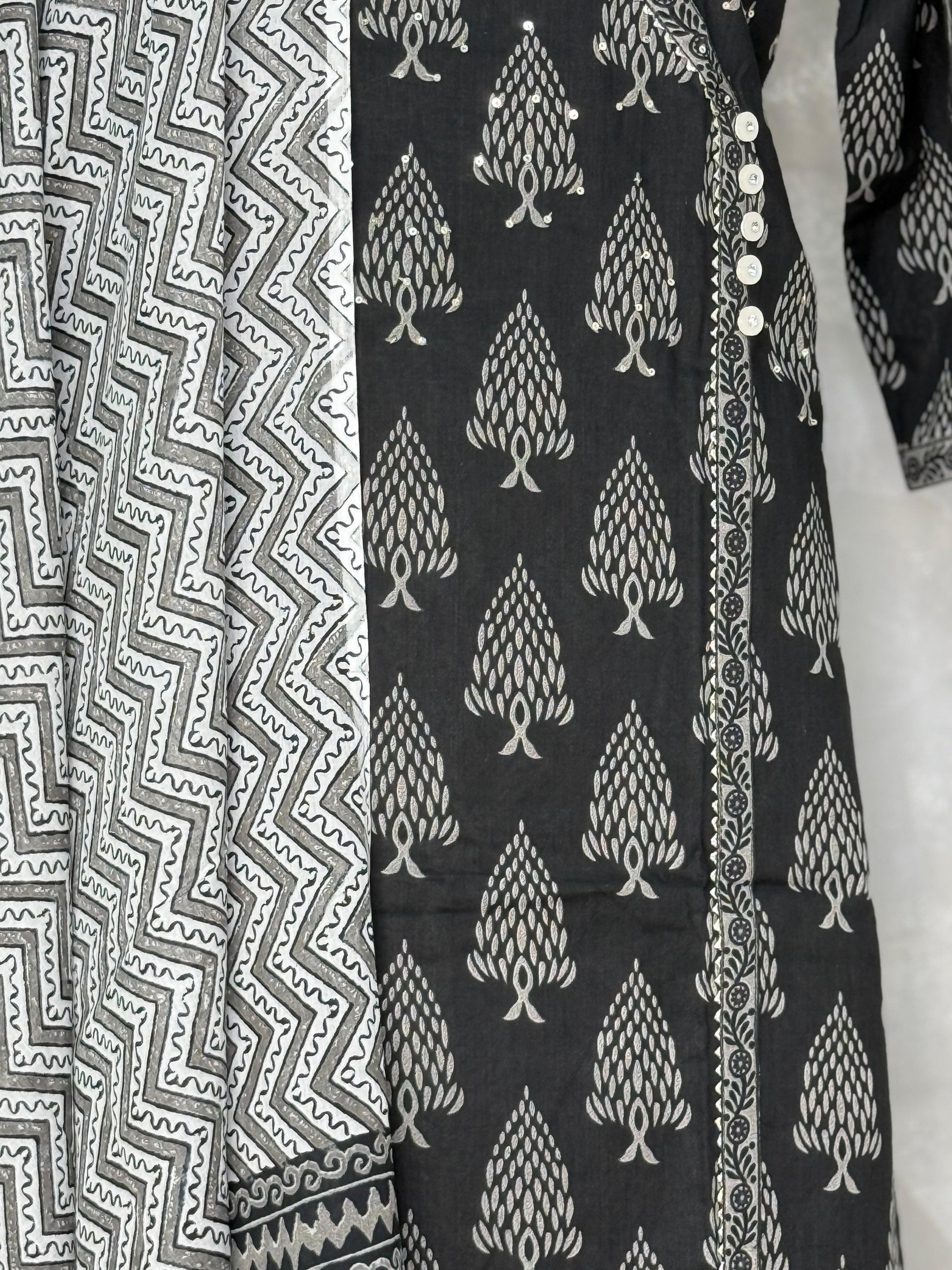 Black fabric with white tree pattern next to gray fabric with zigzag pattern