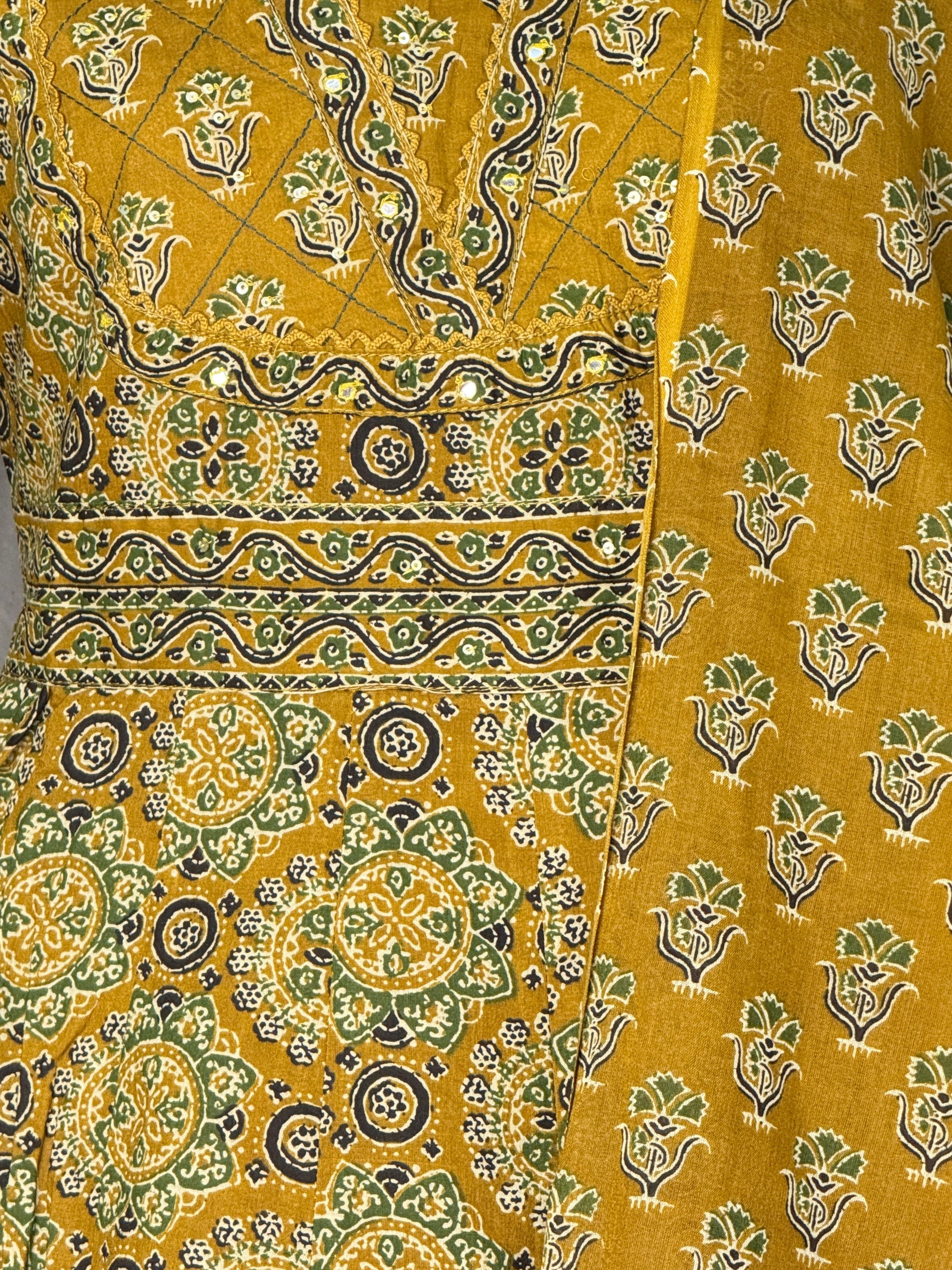 Close-up of yellow fabric with green and black floral patterns