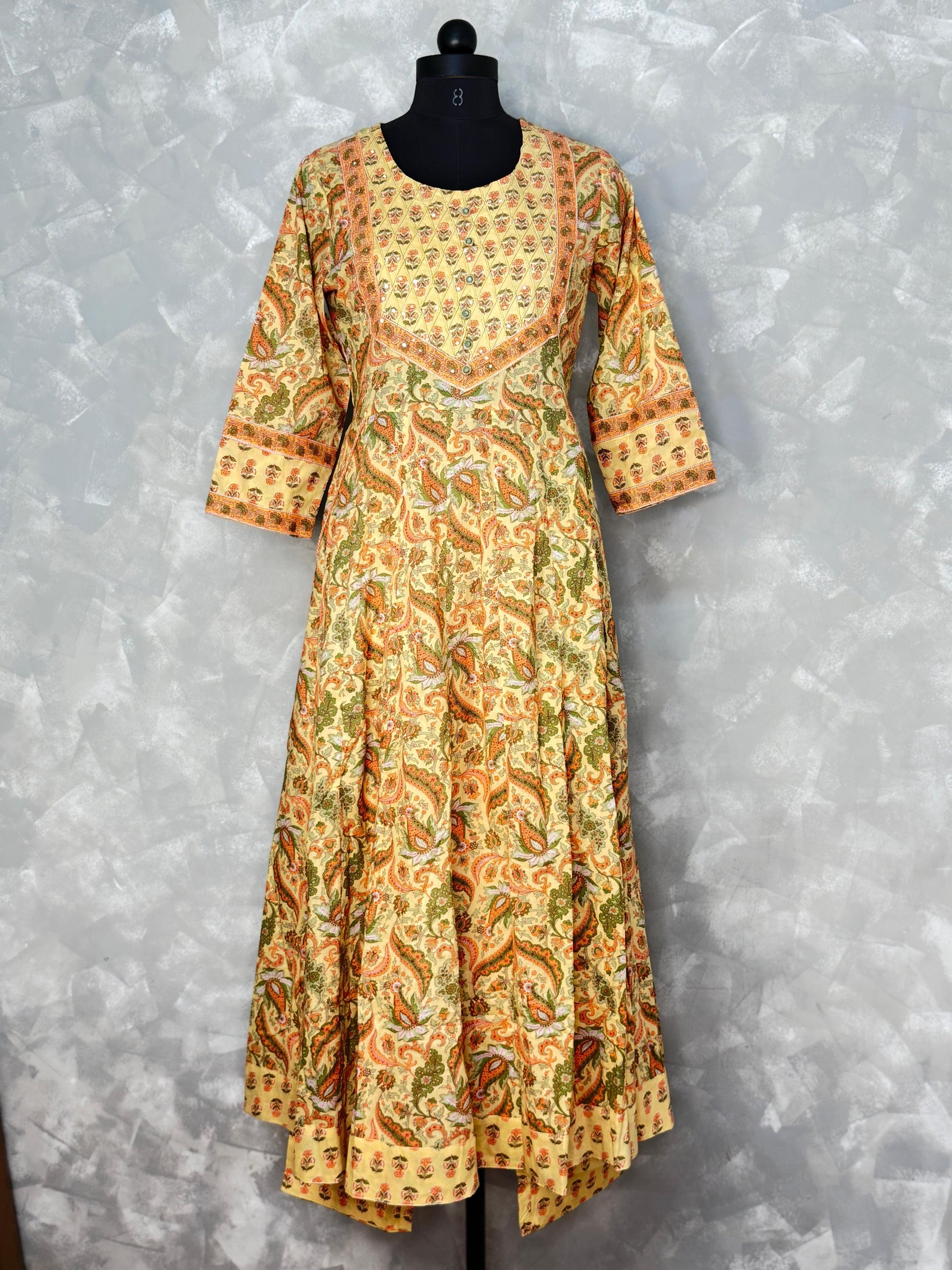 Long patterned dress on a mannequin against a gray background