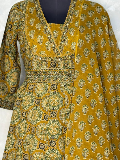 Mustard yellow and green patterned traditional outfit with a plain background