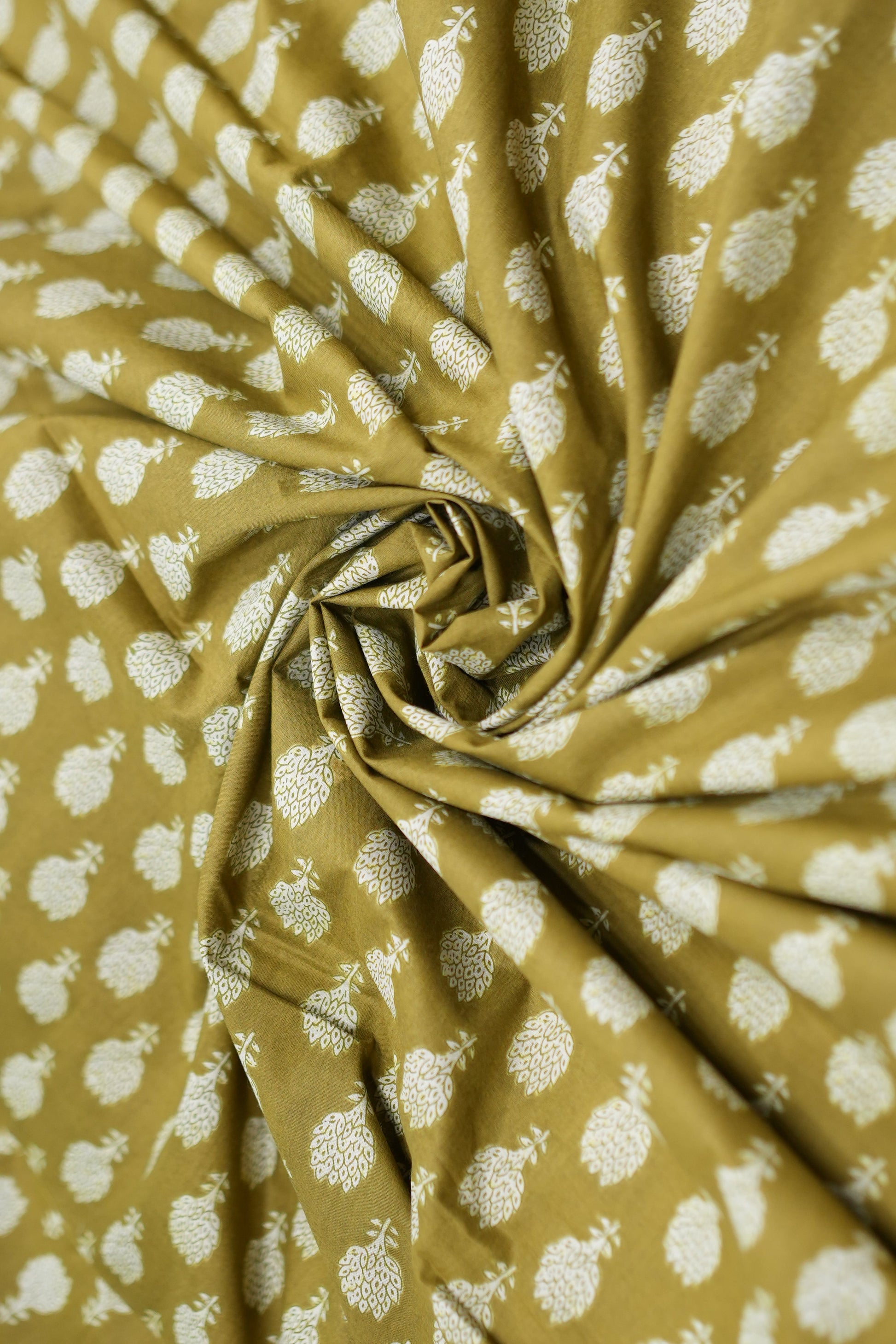 Roll of fabric with white floral pattern on a mustard yellow background