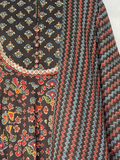 Traditional patterned fabric with colorful designs on a black background