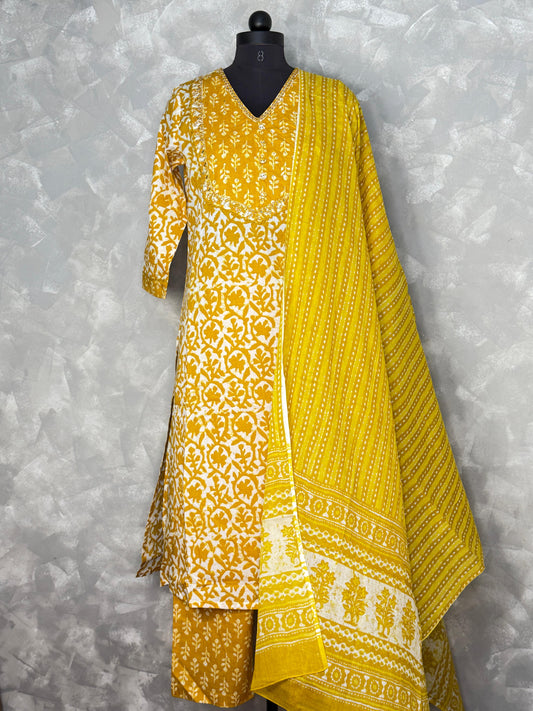 Yellow and white patterned dress on a mannequin against a gray background