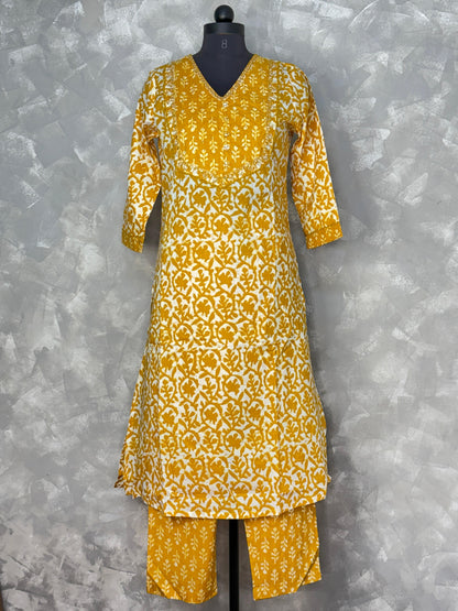 Yellow and white patterned kurta set on a mannequin against a gray background